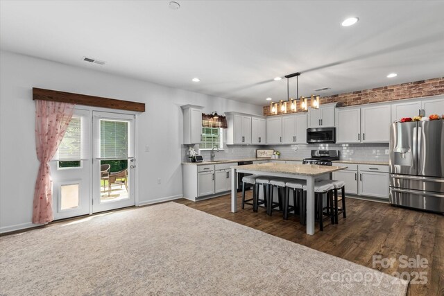 301 Wheat Field Dr, Mount Holly, NC 28120 - kitchen with appliances with stainless steel finishes, a sink, a kitchen bar, backsplash, and a kitchen island