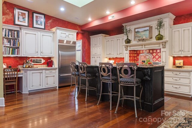 231 N Main St, Hendersonville, NC 28792 - kitchen featuring built in fridge, dark wood finished floors, white cabinetry, a breakfast bar area, and recessed lighting