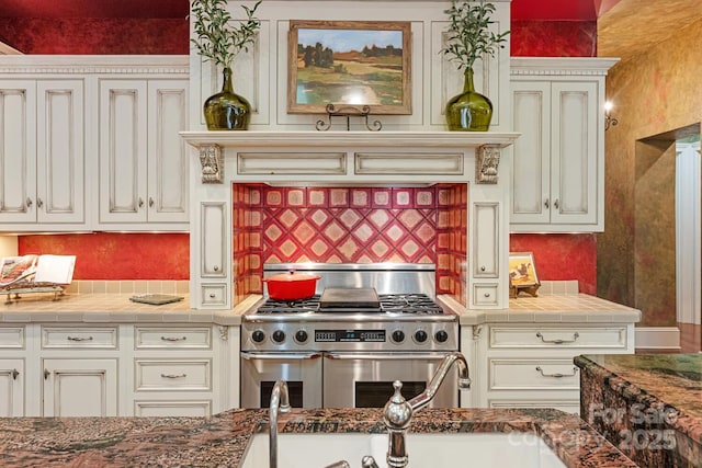 231 N Main St, Hendersonville, NC 28792 - kitchen with range with two ovens, decorative backsplash, and white cabinetry