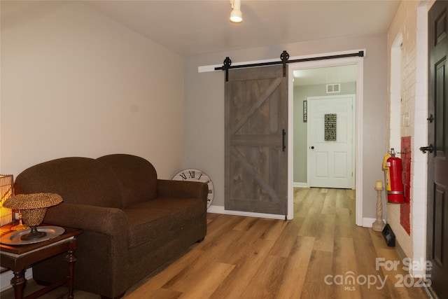 1028 Washburn Switch Rd, Shelby, NC 28150 - living area featuring a barn door, wood finished floors, and baseboards