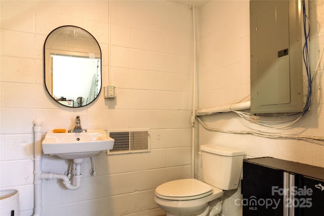 1028 Washburn Switch Rd, Shelby, NC 28150 - half bath with electric panel, toilet, and concrete block wall