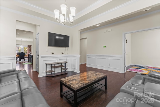966 NW Parkland Pl, Concord, NC 28027 - living room featuring a chandelier, wood finished floors, crown molding, and wainscoting
