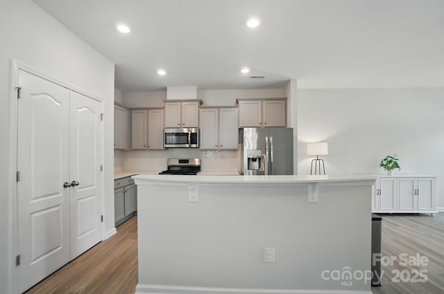 5334 Orchid Bloom Dr, Fort Mill, SC 29707 - kitchen featuring stainless steel appliances, gray cabinetry, wood finished floors, tasteful backsplash, and recessed lighting