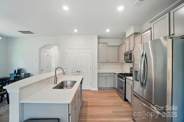 5334 Orchid Bloom Dr, Fort Mill, SC 29707 - kitchen featuring stainless steel appliances, a sink, gray cabinetry, light wood-type flooring, and light countertops