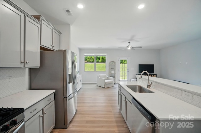 5334 Orchid Bloom Dr, Fort Mill, SC 29707 - kitchen with stainless steel appliances, a sink, gray cabinets, a ceiling fan, and backsplash