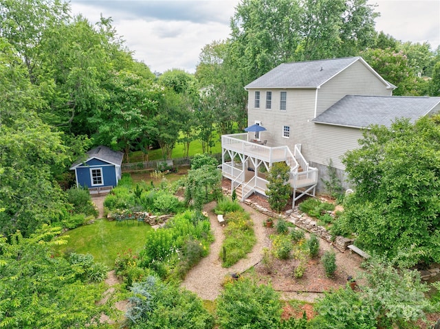 7 Mill Stone Dr, Asheville, NC 28803 - back of house with a wooden deck, a shingled roof, a storage unit, and view of wooded area