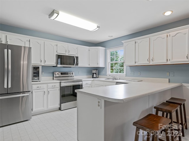 7 Mill Stone Dr, Asheville, NC 28803 - kitchen with appliances with stainless steel finishes, a peninsula, a breakfast bar, light countertops, and recessed lighting