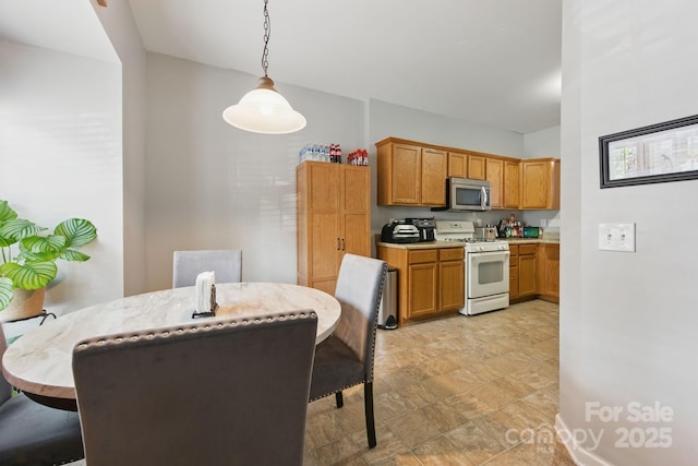 158 Snead Rd, Fort Mill, SC 29715 - kitchen featuring white gas stove, stainless steel microwave, hanging light fixtures, brown cabinets, and a breakfast bar area