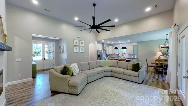 3633 Longpond Ln, Monroe, NC 28110 - living area featuring light wood-style flooring, a ceiling fan, a high ceiling, recessed lighting, and baseboards