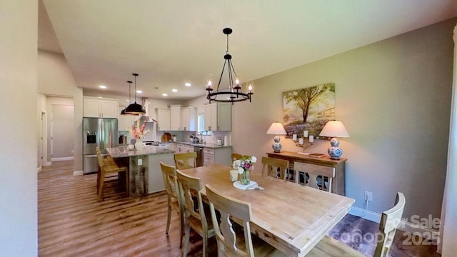 3633 Longpond Ln, Monroe, NC 28110 - dining room featuring wood finished floors, a chandelier, recessed lighting, and baseboards