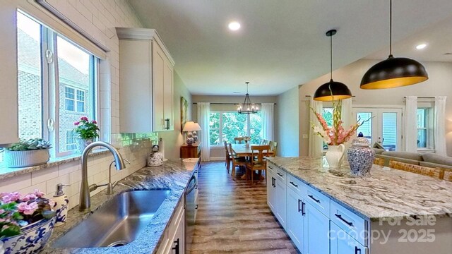 3633 Longpond Ln, Monroe, NC 28110 - kitchen featuring a sink, white cabinets, decorative backsplash, wood finished floors, and light stone countertops