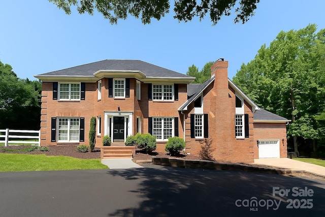 315 Red Barn Trl, Matthews, NC 28104 - colonial home featuring a chimney, brick siding, a garage, and driveway