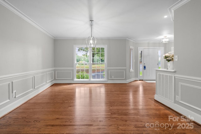 315 Red Barn Trl, Matthews, NC 28104 - unfurnished dining area with a chandelier, crown molding, wood finished floors, a decorative wall, and a wainscoted wall