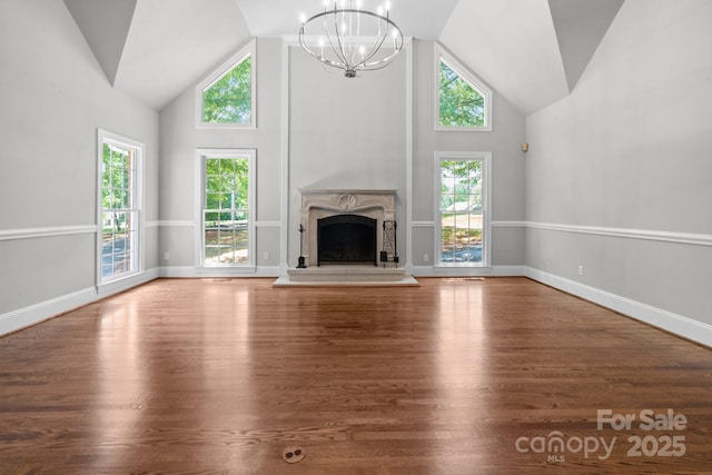 315 Red Barn Trl, Matthews, NC 28104 - unfurnished living room with high vaulted ceiling, a chandelier, wood finished floors, and a fireplace