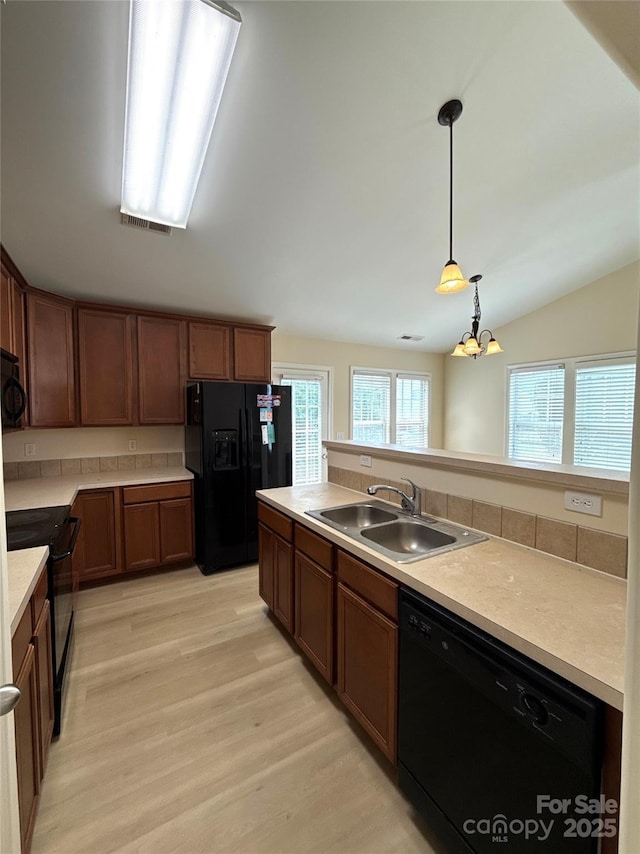 1423 Napa St NW, Concord, NC 28027 - kitchen featuring black appliances, a sink, light wood finished floors, a chandelier, and light countertops