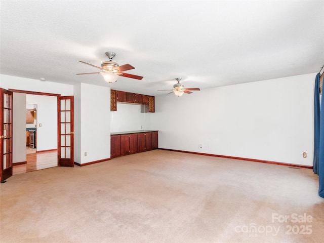 51 Wake Robin Way, Asheville, NC 28805 - unfurnished living room featuring a ceiling fan, light colored carpet, baseboards, and french doors