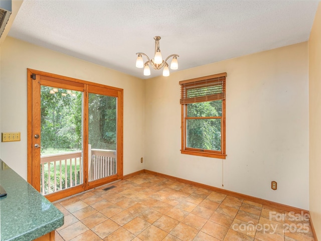 51 Wake Robin Way, Asheville, NC 28805 - unfurnished dining area with a chandelier, a textured ceiling, and baseboards