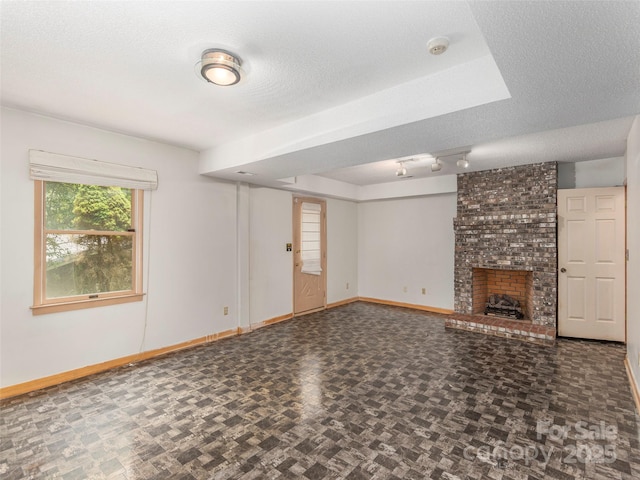 51 Wake Robin Way, Asheville, NC 28805 - unfurnished living room with baseboards, a fireplace, rail lighting, and a textured ceiling