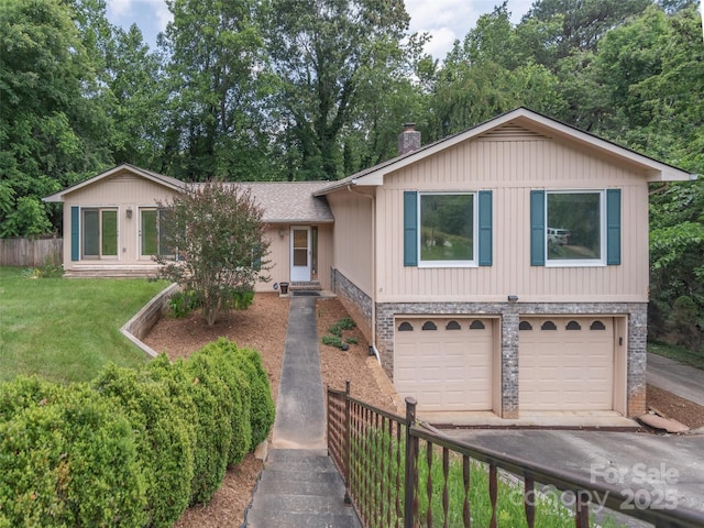 51 Wake Robin Way, Asheville, NC 28805 - split level home featuring an attached garage, a chimney, driveway, stone siding, and view of scattered trees
