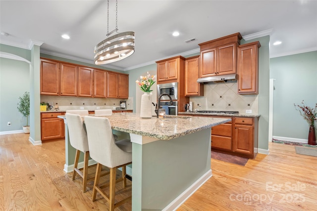 137 Leaning Tower Dr, Mooresville, NC 28117 - kitchen featuring stainless steel microwave, a sink, backsplash, a center island with sink, and ornamental molding