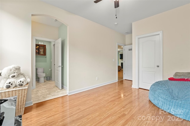 137 Leaning Tower Dr, Mooresville, NC 28117 - bedroom featuring arched walkways, light wood finished floors, ensuite bathroom, baseboards, and a ceiling fan
