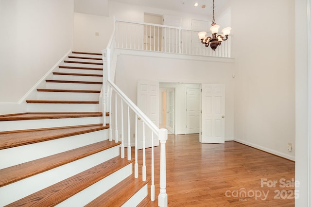 6823 Manatee Dr, Concord, NC 28025 - stairway with a chandelier, wood finished floors, a high ceiling, baseboards, and recessed lighting