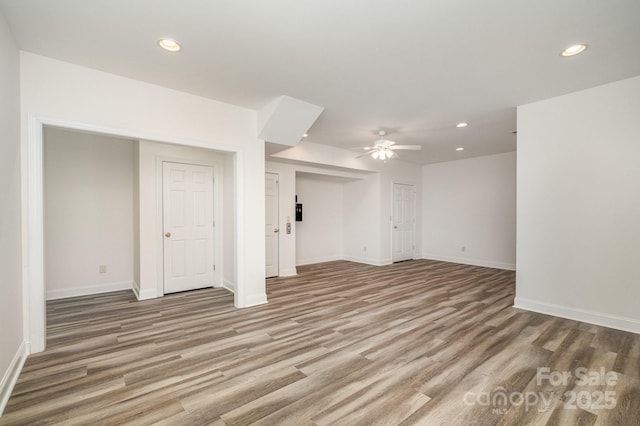 6823 Manatee Dr, Concord, NC 28025 - unfurnished living room with a ceiling fan, recessed lighting, wood finished floors, and baseboards