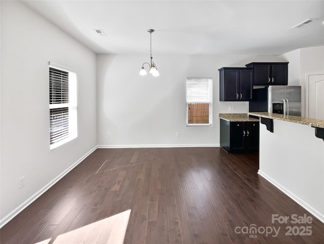 108 Greenway View Ct, Mount Holly, NC 28120 - kitchen with stainless steel fridge, a kitchen bar, a chandelier, light stone countertops, and dark cabinets