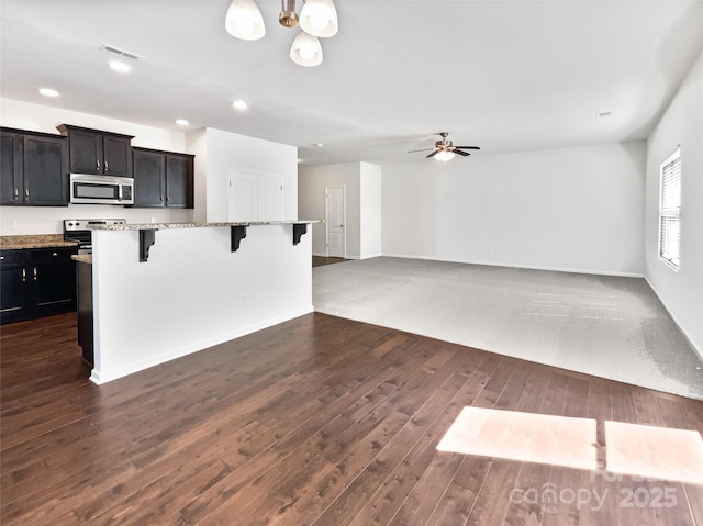 108 Greenway View Ct, Mount Holly, NC 28120 - kitchen featuring stainless steel appliances, a breakfast bar area, dark wood finished floors, light stone counters, and recessed lighting
