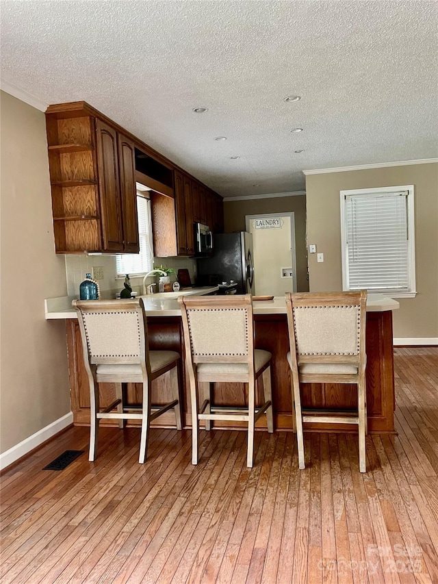 218 Hardin Cir, Grover, NC 28073 - kitchen featuring stainless steel microwave, open shelves, light wood-style flooring, ornamental molding, and a textured ceiling