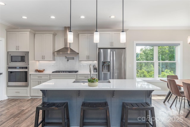 17 Baxter Woods Ln, Candler, NC 28715 - kitchen with stainless steel appliances, wall chimney exhaust hood, crown molding, a breakfast bar, and light countertops