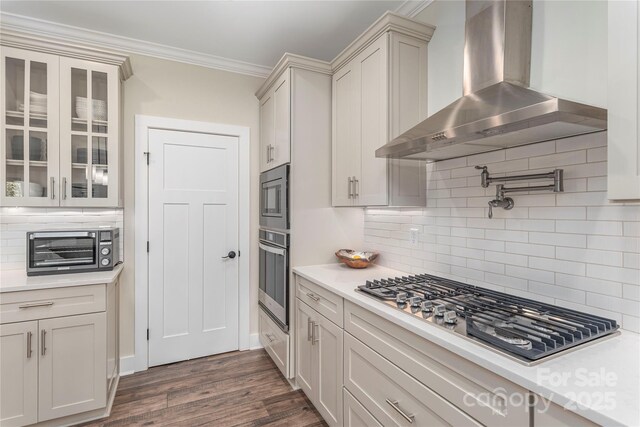 17 Baxter Woods Ln, Candler, NC 28715 - kitchen featuring wall chimney range hood, stainless steel appliances, light countertops, ornamental molding, and glass insert cabinets