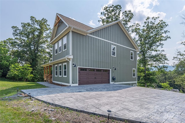 17 Baxter Woods Ln, Candler, NC 28715 - view of home's exterior with an attached garage, decorative driveway, board and batten siding, and a yard