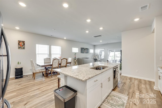 322 Olympia Way, York, SC 29745 - kitchen featuring a sink, stainless steel appliances, white cabinetry, light wood-style flooring, and a center island with sink