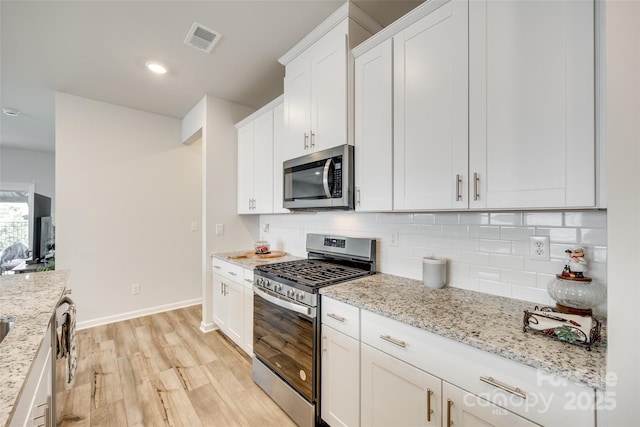 322 Olympia Way, York, SC 29745 - kitchen featuring appliances with stainless steel finishes, light wood-style flooring, baseboards, tasteful backsplash, and white cabinetry