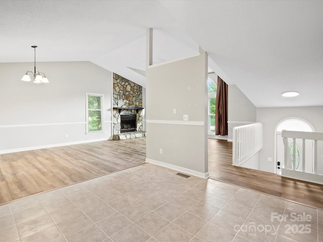 3124 5th Street Pl NE, Hickory, NC 28601 - unfurnished living room featuring tile patterned floors, vaulted ceiling, a fireplace, a chandelier, and baseboards