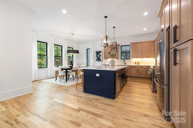 3903 Plainview Rd, Charlotte, NC 28208 - kitchen with a sink, light countertops, a kitchen island, light wood-style flooring, and a breakfast bar