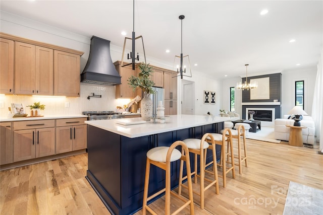 3903 Plainview Rd, Charlotte, NC 28208 - kitchen featuring premium range hood, light wood-type flooring, decorative backsplash, a center island, and a chandelier