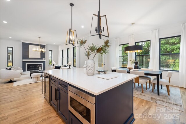 3903 Plainview Rd, Charlotte, NC 28208 - kitchen with stainless steel microwave, light wood-type flooring, light countertops, decorative light fixtures, and a chandelier