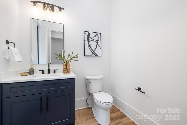 3903 Plainview Rd, Charlotte, NC 28208 - bathroom featuring toilet, vanity, wood finished floors, and baseboards