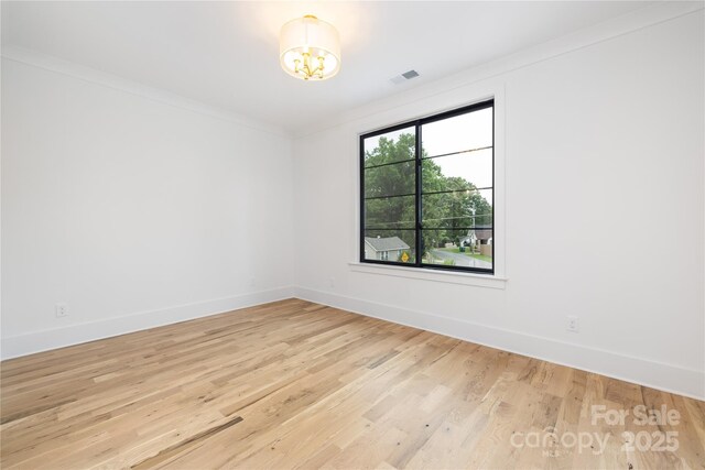 3903 Plainview Rd, Charlotte, NC 28208 - spare room with a chandelier, light wood finished floors, baseboards, and ornamental molding