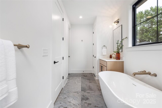 3903 Plainview Rd, Charlotte, NC 28208 - bathroom featuring a freestanding bath, vanity, plenty of natural light, and marble finish floors