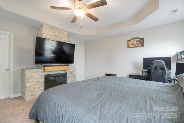 198 Anita Ln, Lexington, NC 27295 - carpeted bedroom with a fireplace, a ceiling fan, and a tray ceiling
