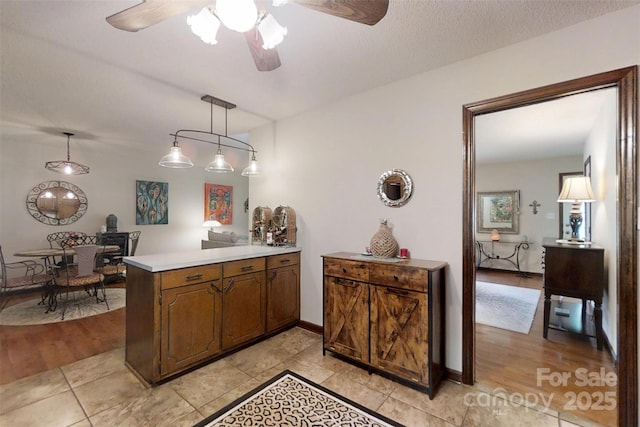 4920 Surfwood Dr, Sherrills Ford, NC 28673 - kitchen with a peninsula, light countertops, a ceiling fan, hanging light fixtures, and baseboards