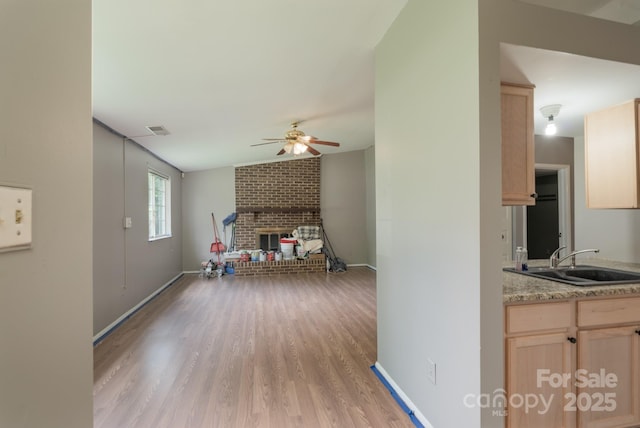 8019 Walnut Creek Ln, Charlotte, NC 28227 - unfurnished living room featuring a ceiling fan, light wood-style flooring, and a brick fireplace