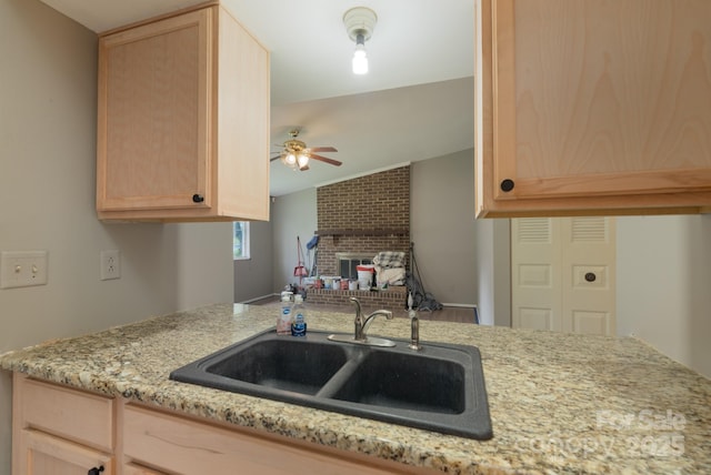 8019 Walnut Creek Ln, Charlotte, NC 28227 - kitchen with light brown cabinetry, ceiling fan, a brick fireplace, vaulted ceiling, and light stone counters