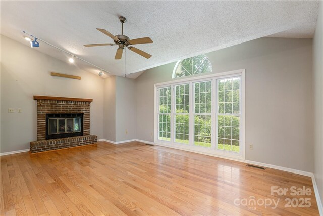 93 Wood Duck Ct, Brevard, NC 28712 - unfurnished living room featuring a textured ceiling, lofted ceiling, wood finished floors, a ceiling fan, and track lighting