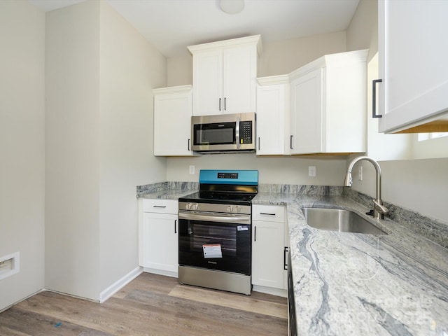614 Kings Mountain St, Clover, SC 29710 - kitchen with appliances with stainless steel finishes, light wood-type flooring, light stone counters, and white cabinetry