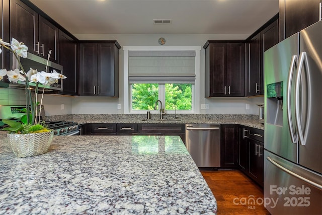 253 Flat Creek Rd, Black Mountain, NC 28711 - kitchen with appliances with stainless steel finishes, a sink, light stone countertops, and dark brown cabinets