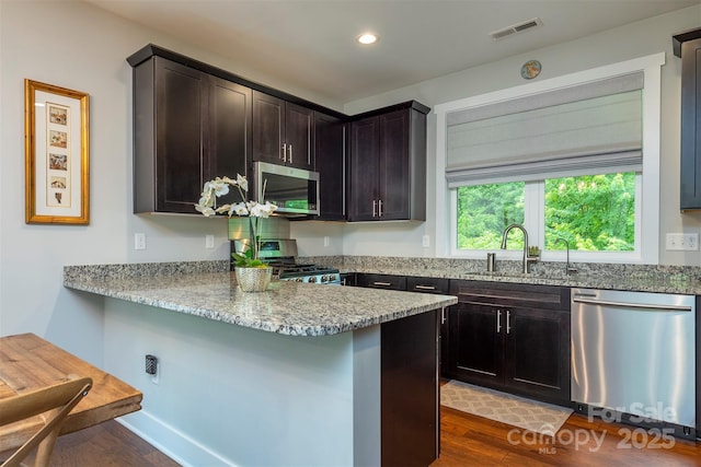 253 Flat Creek Rd, Black Mountain, NC 28711 - kitchen with stainless steel appliances, a sink, dark wood-type flooring, light stone counters, and a peninsula